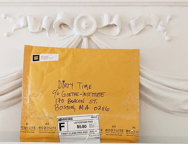 An envelope addressed to Goethe Institut leaning against a plasterwork white ribbon